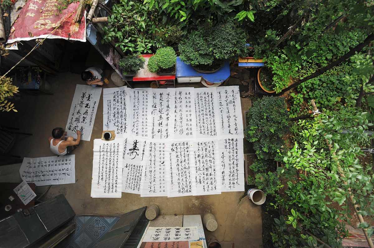 2015年7月20日,大李村一隅,严远承在自家院中研习书法.
