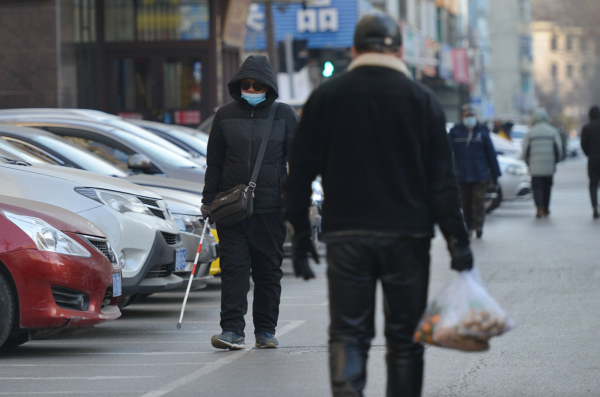 2021年1月3日,辽宁省沈阳市,疫情防控下,残障盲人戴口罩出行散步,平时