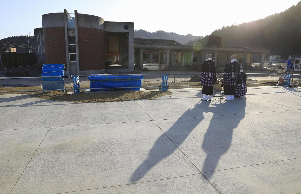 当地时间2021年3月11日,日本宫城县石卷市,僧侣们在当地一所受灾严重