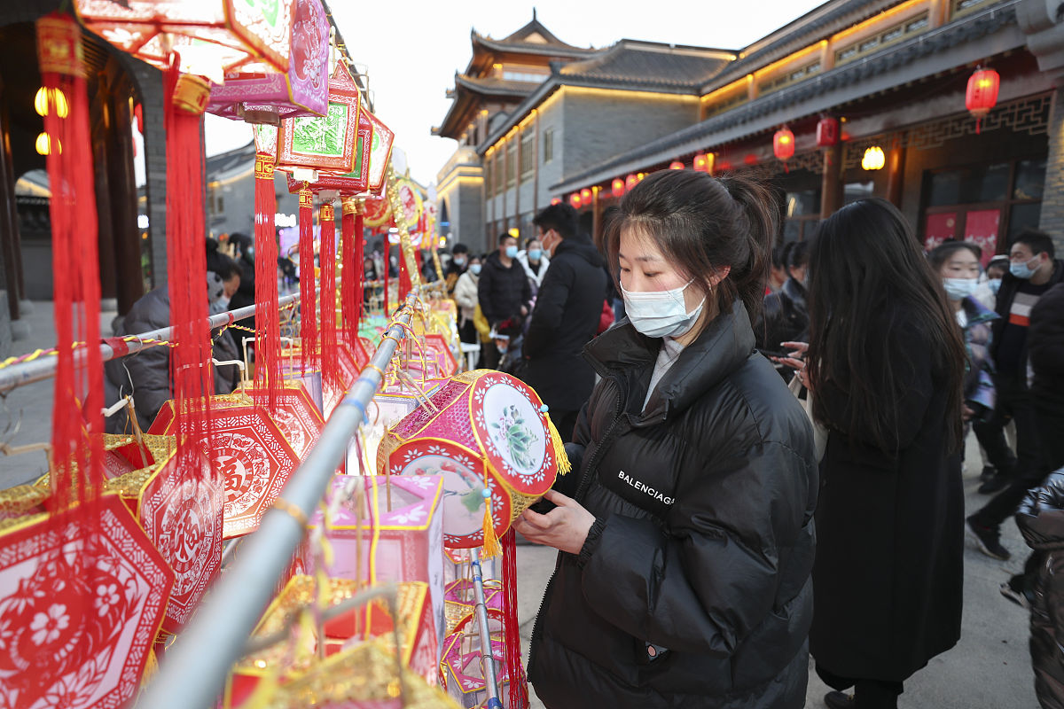 2021年2月16日,江苏连云港,市民在赣榆区花灯市场展示挑选传统花灯.