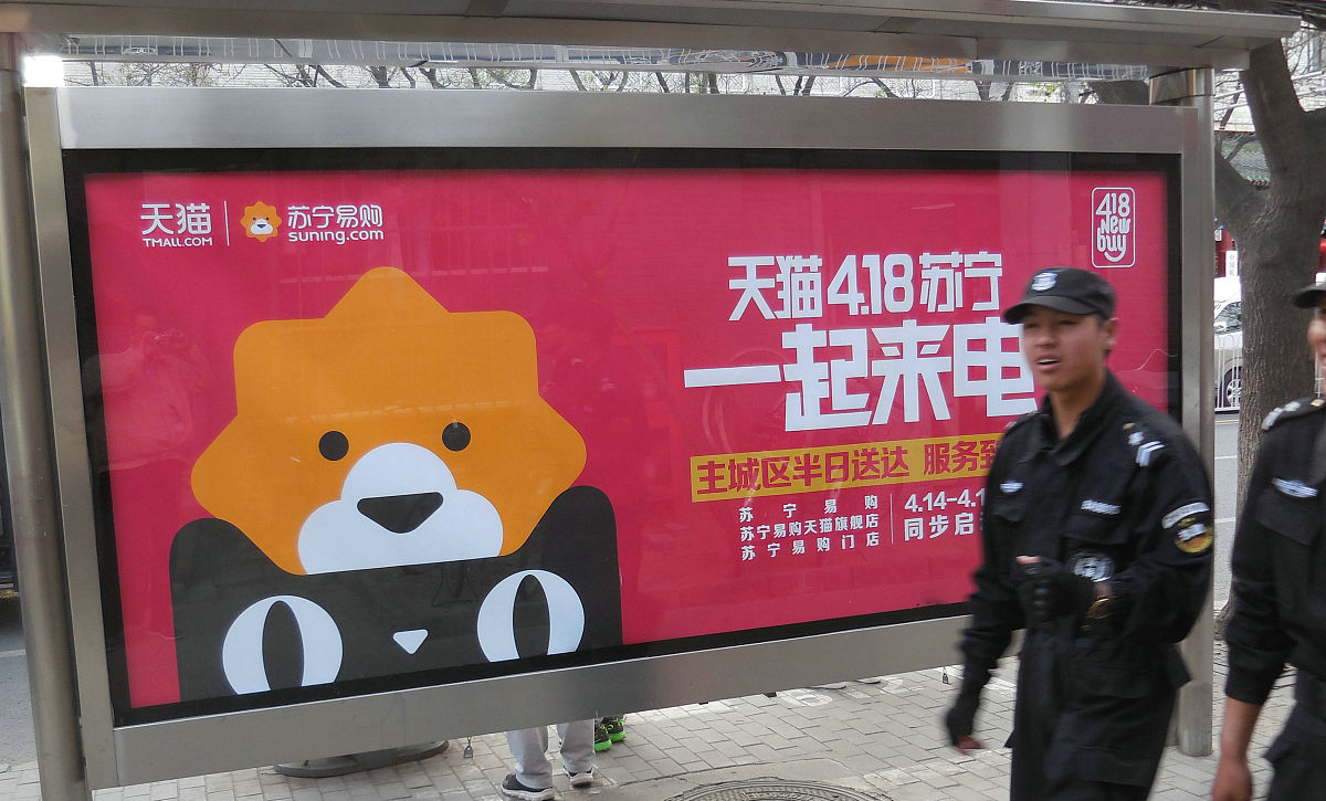2016年4月7日,北京街头行人从"天猫和苏宁易购启动的418购物狂欢节一