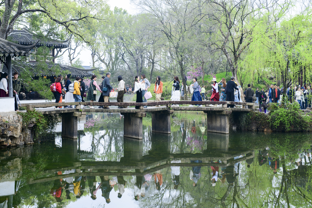2026年3月30日,江苏苏州,游客在拙政园内撑伞漫步.