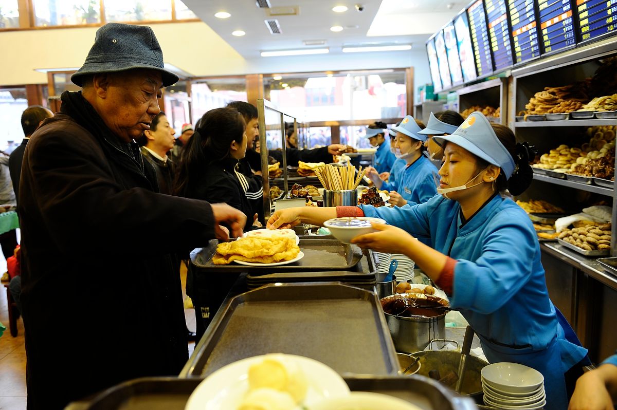 为了享用一下北京的美食夫妻两个人在一家早餐店用餐意思不变重新写一句