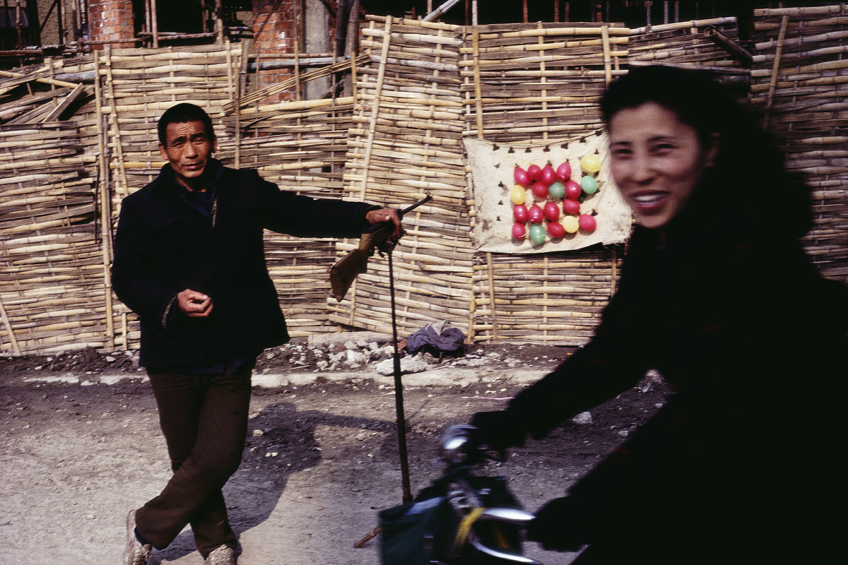 1990年代,上海,路边的气球打靶摊,是街头常见的娱乐活动之一.a women 