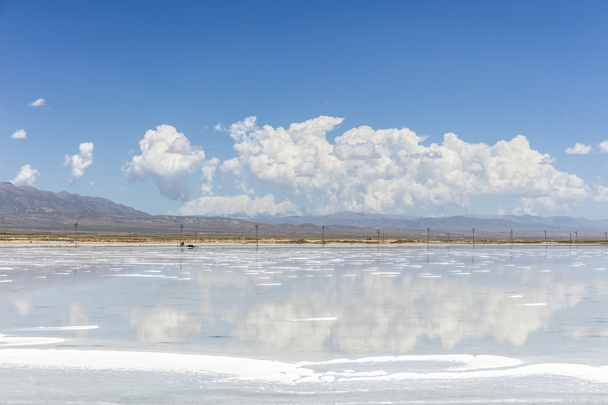 夏日的阳光洒落在青海茶卡盐湖上,犹如一面闪耀的镜子,倒映着天空