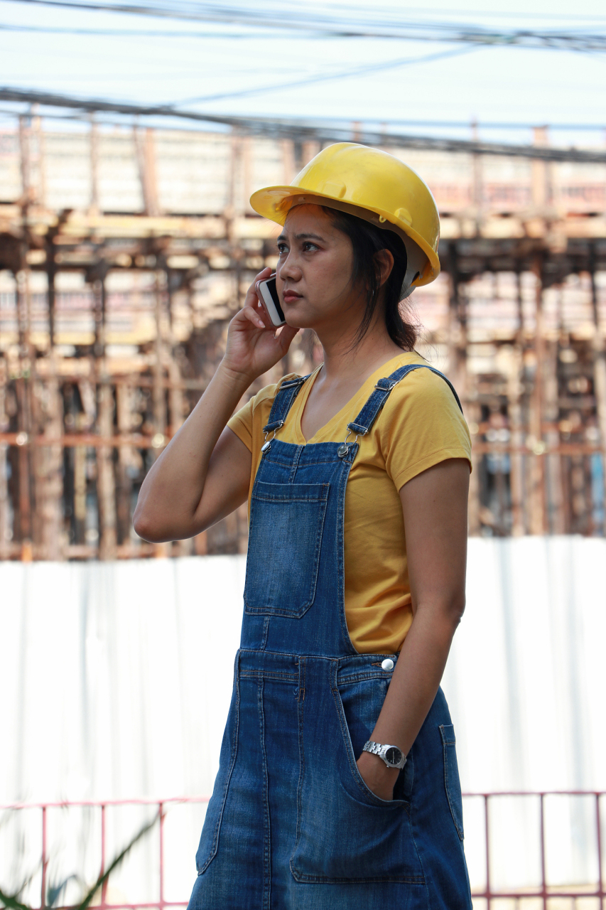 开篇一张照片,一个23岁的女生站在工地里,头戴安全帽,身穿工作服,手拿