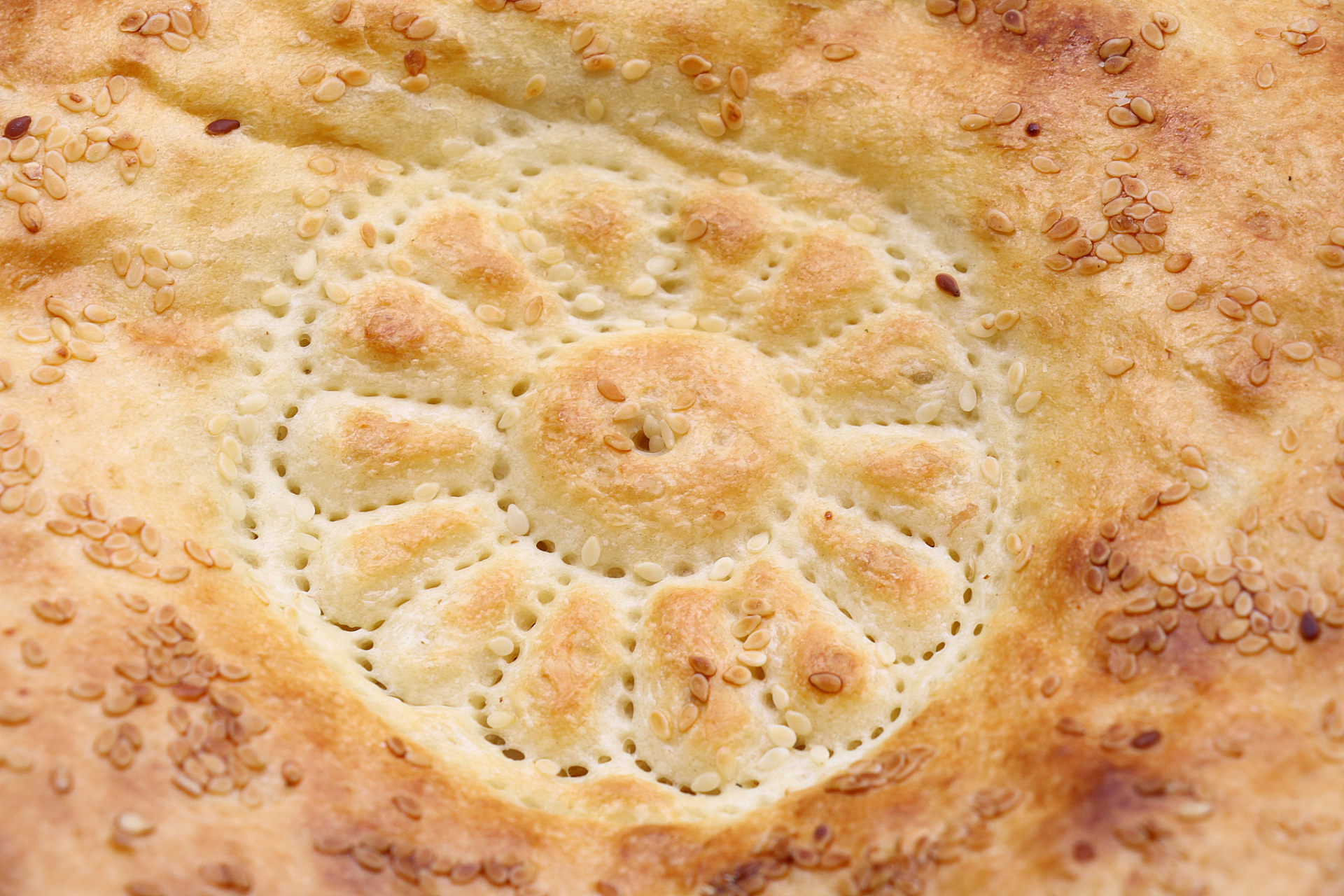 疆称这个为"馕"而不是"馕饼",上面的黑点儿是烤焦的葱,也有放黑芝麻