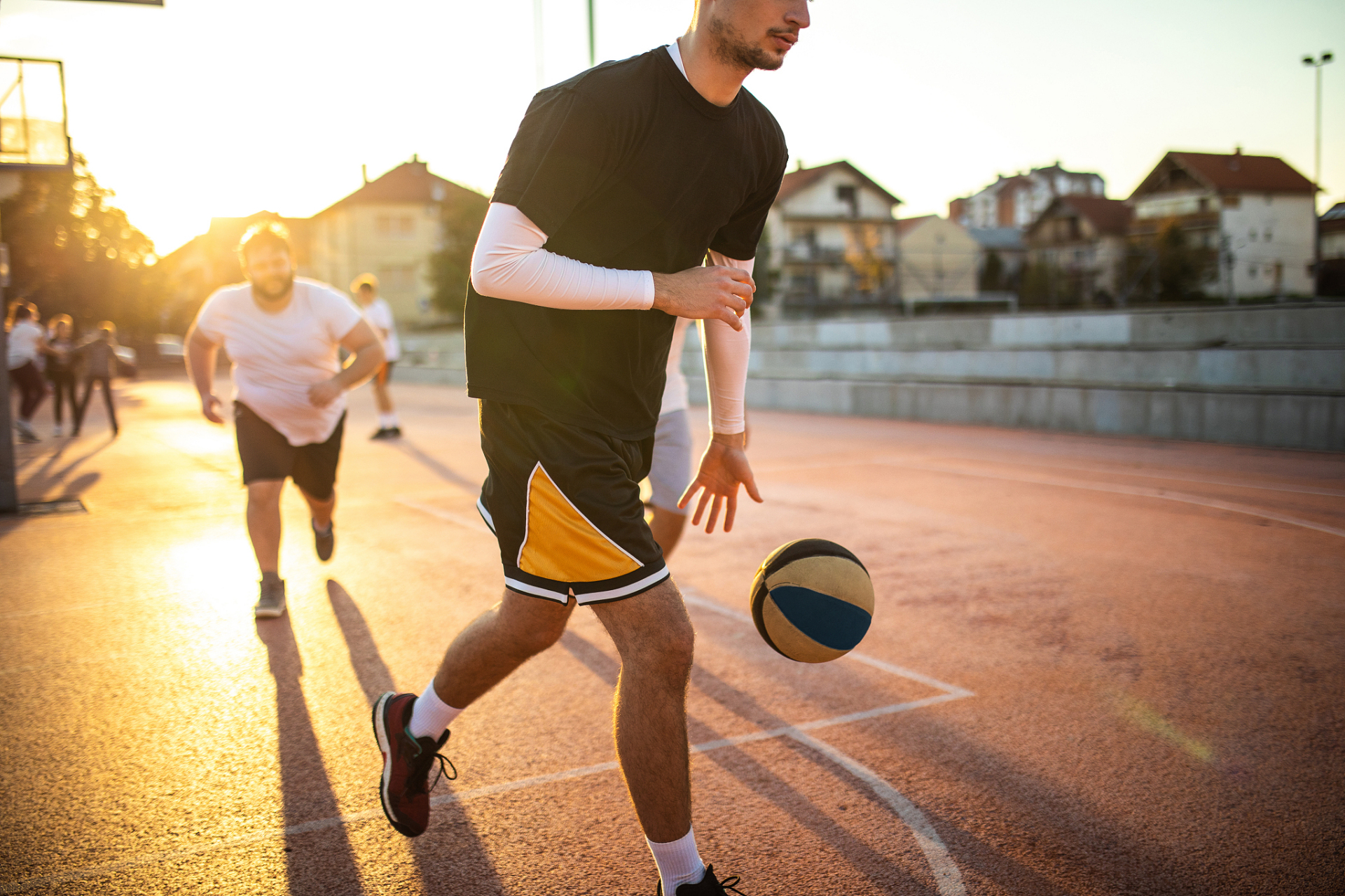 夏天的午后,阳光灿烂,翠绿的草地上,一群年轻人在打篮球.