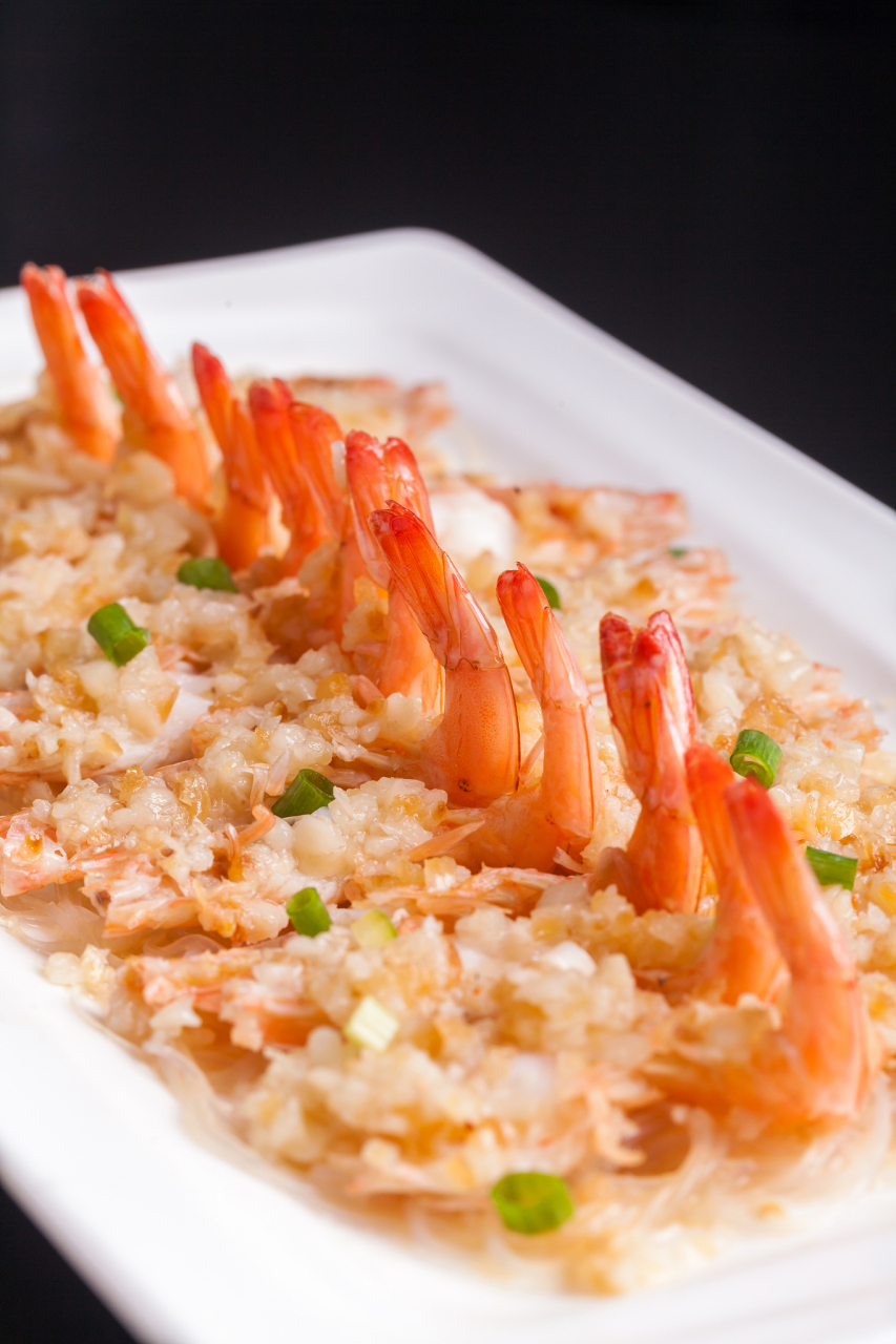 香醋,糖调匀,烧热香油浇在上面调成蒜蓉酱,将蒜蓉酱镶嵌在大虾背部的