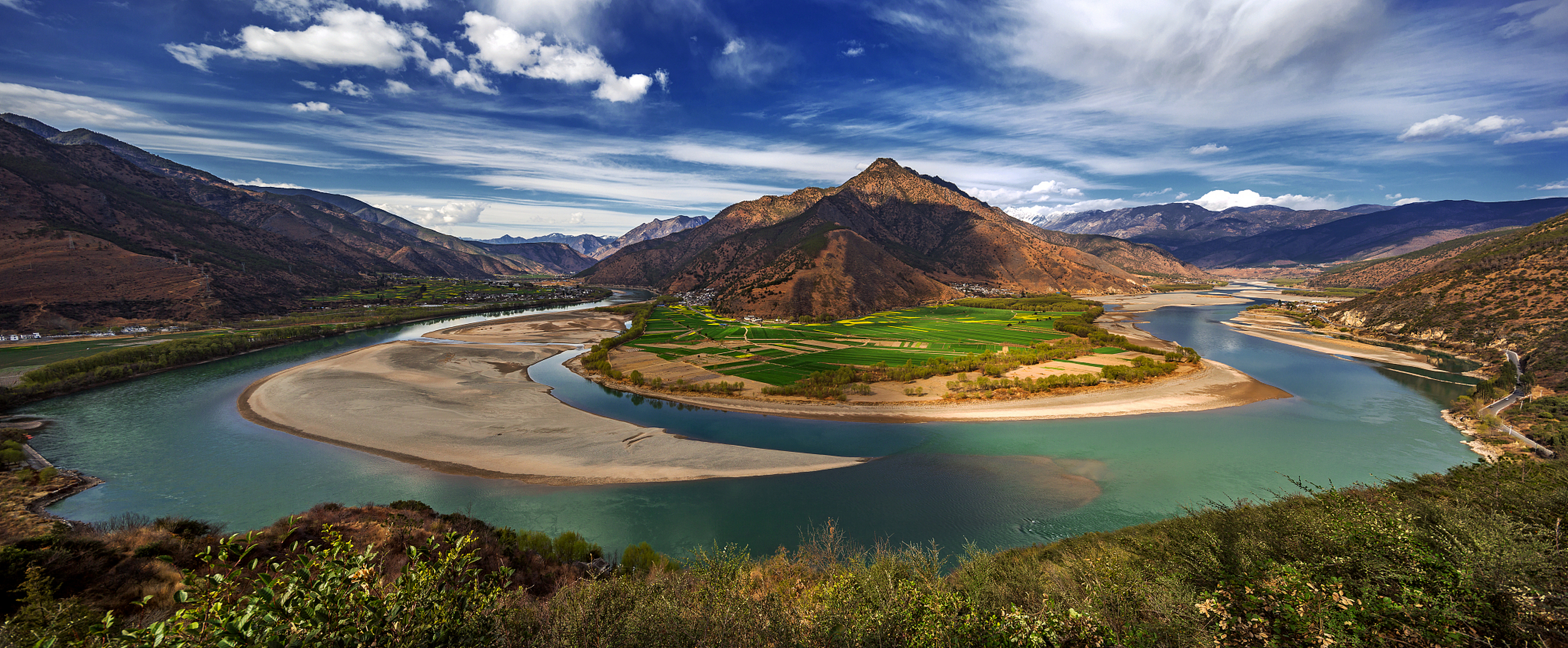 在石鼓镇,长江急转成壮观的"v"形大湾,江水碧绿如宝石.