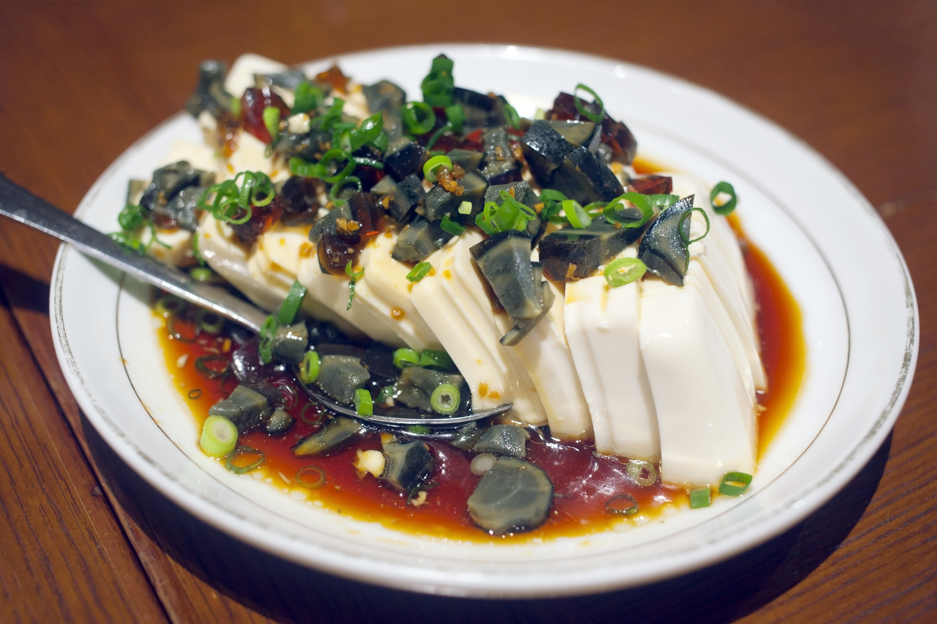 凉拌皮蛋豆腐是一道清爽的凉菜,做法是将皮蛋,内酯豆腐,青椒,香菜等