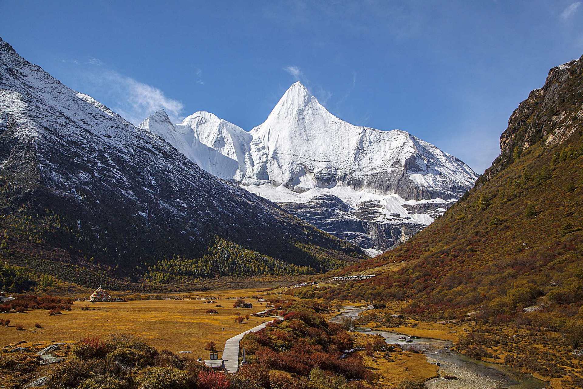 这座山位于四川,由仙乃日,央迈勇,夏诺多吉三座雪峰组成,形成了一个