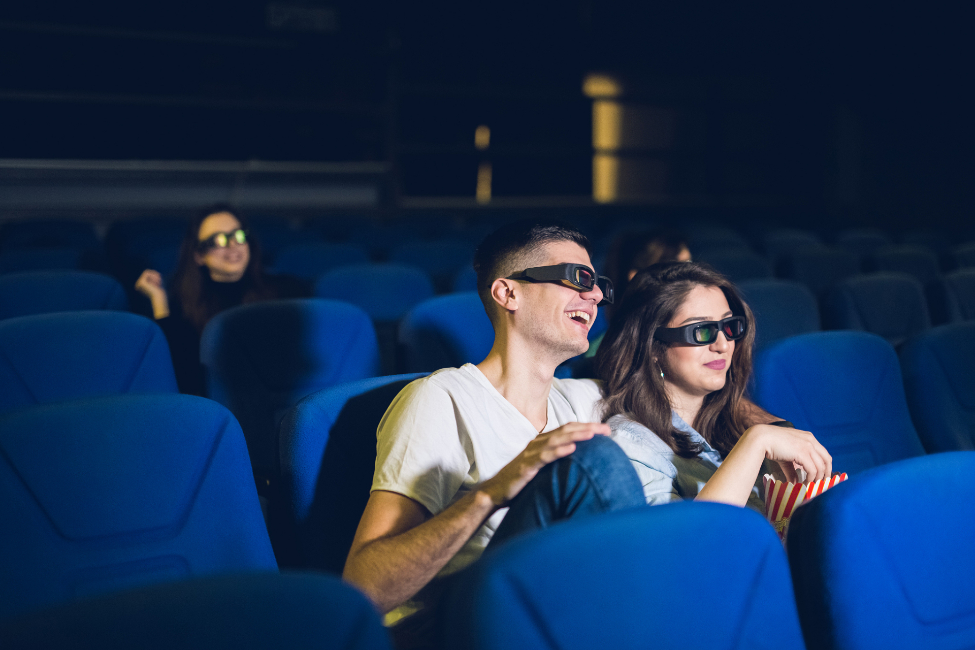 一对情侣在电影院里看电影. 女友对男友说:"你看起来很紧张.