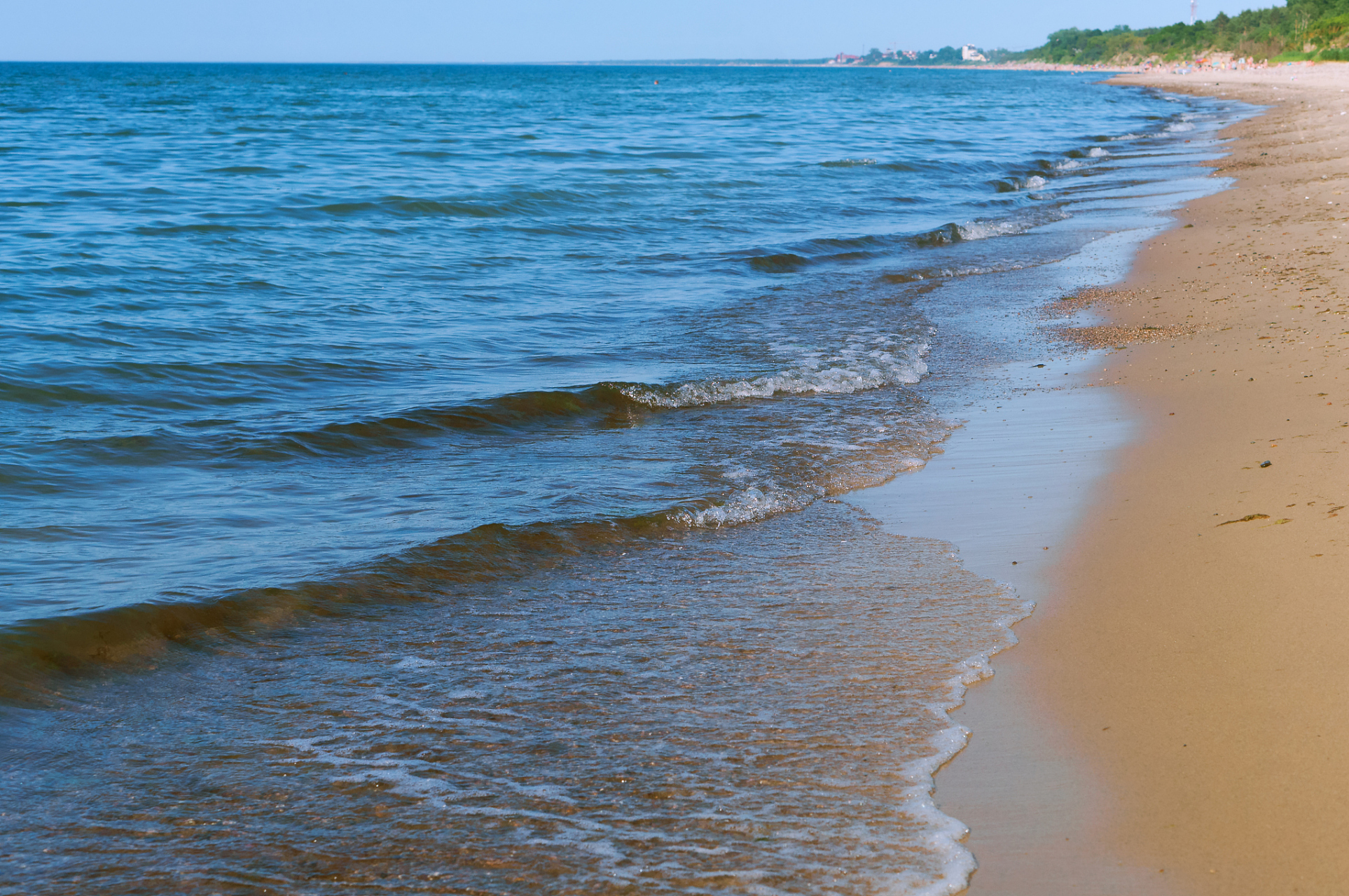 平潭长江澳,春风拂面,海浪轻拍沙滩.游客赤脚踏浪,探索海岛之美.