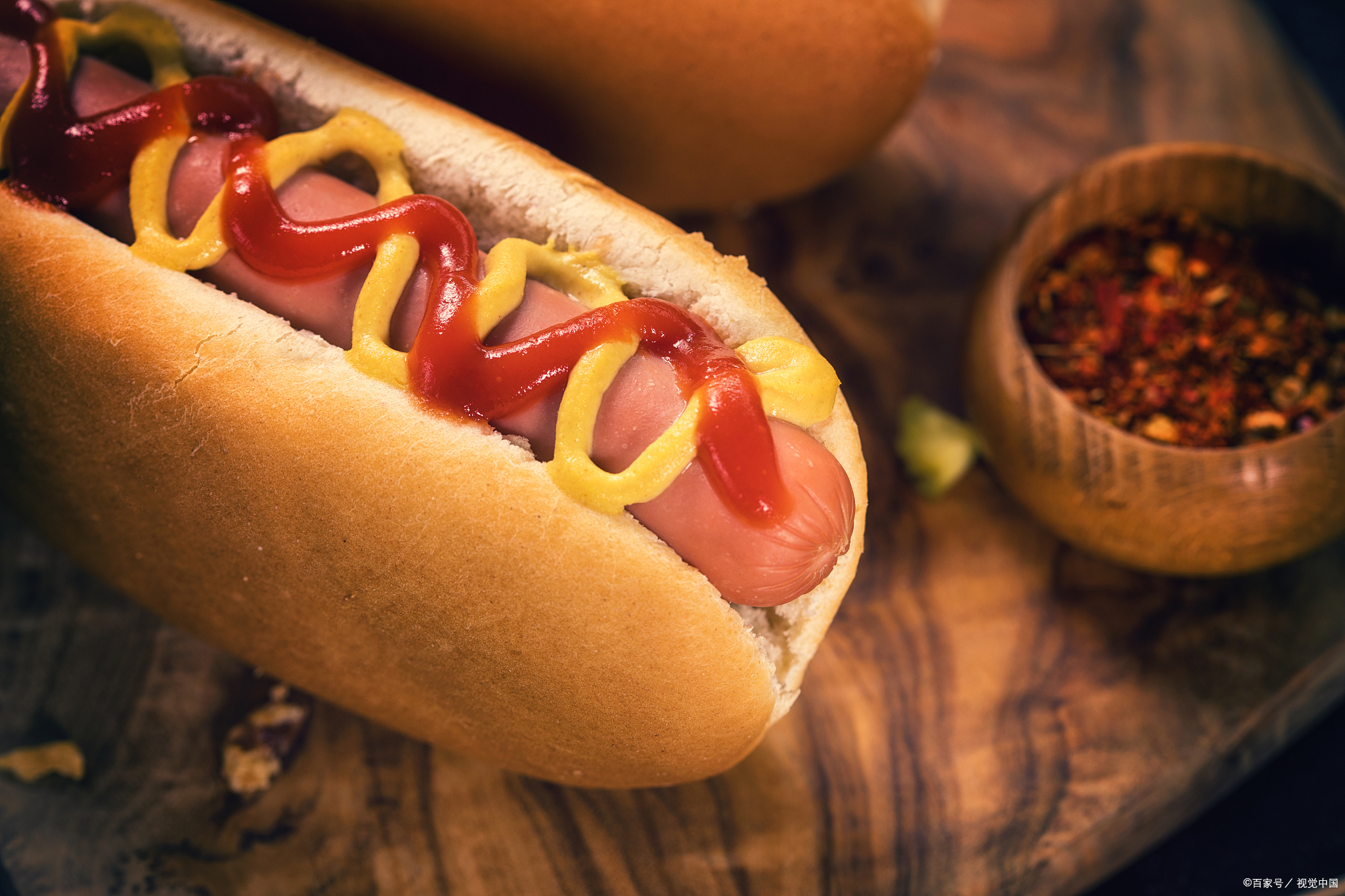 一根长长的面包里夹着一根法兰克福香肠,再配上各种酱料和配菜,如
