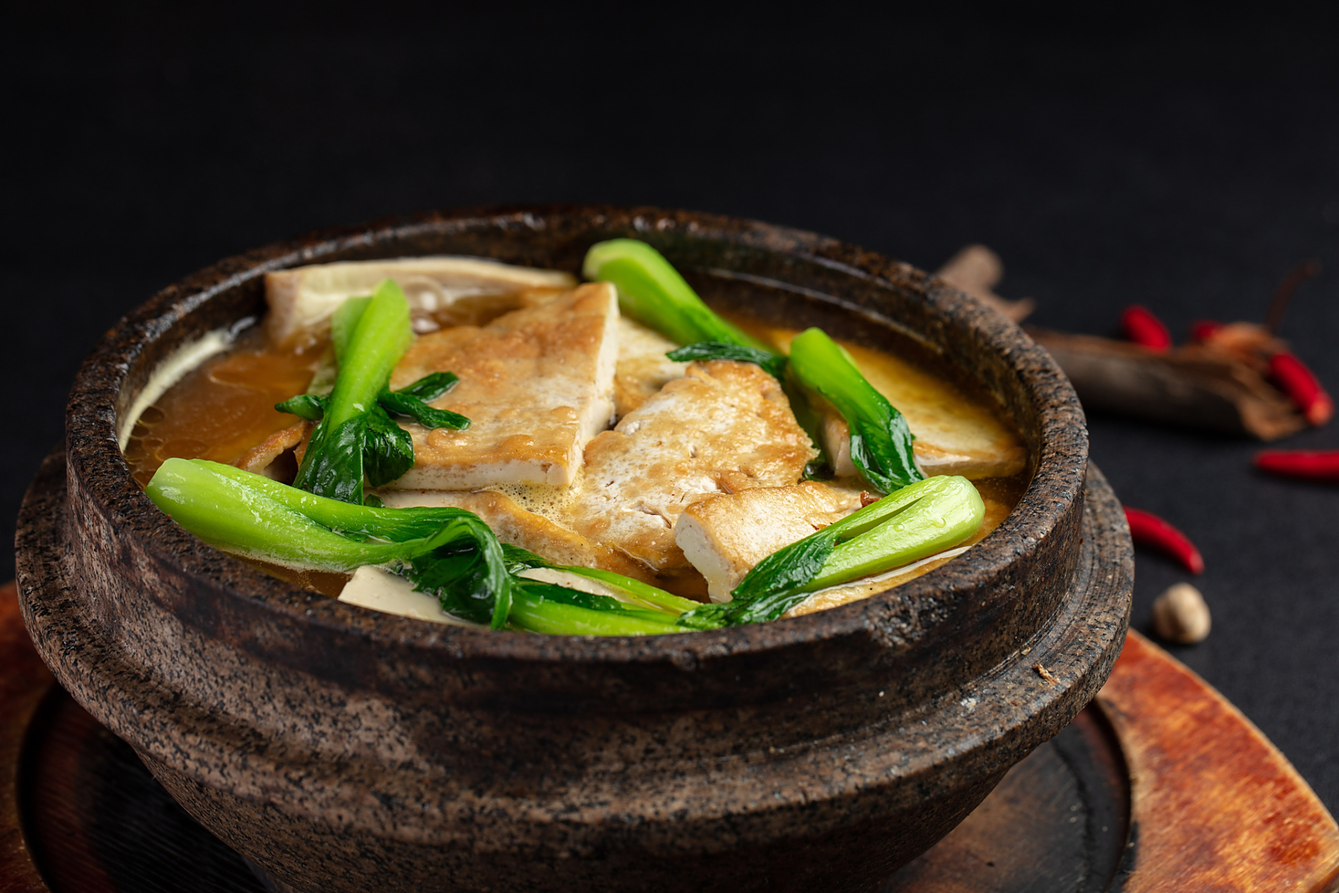 砂锅老豆腐是以老豆腐和熟鸡肉,火腿,海参加上香菇,冬笋,豆苗用砂锅煨