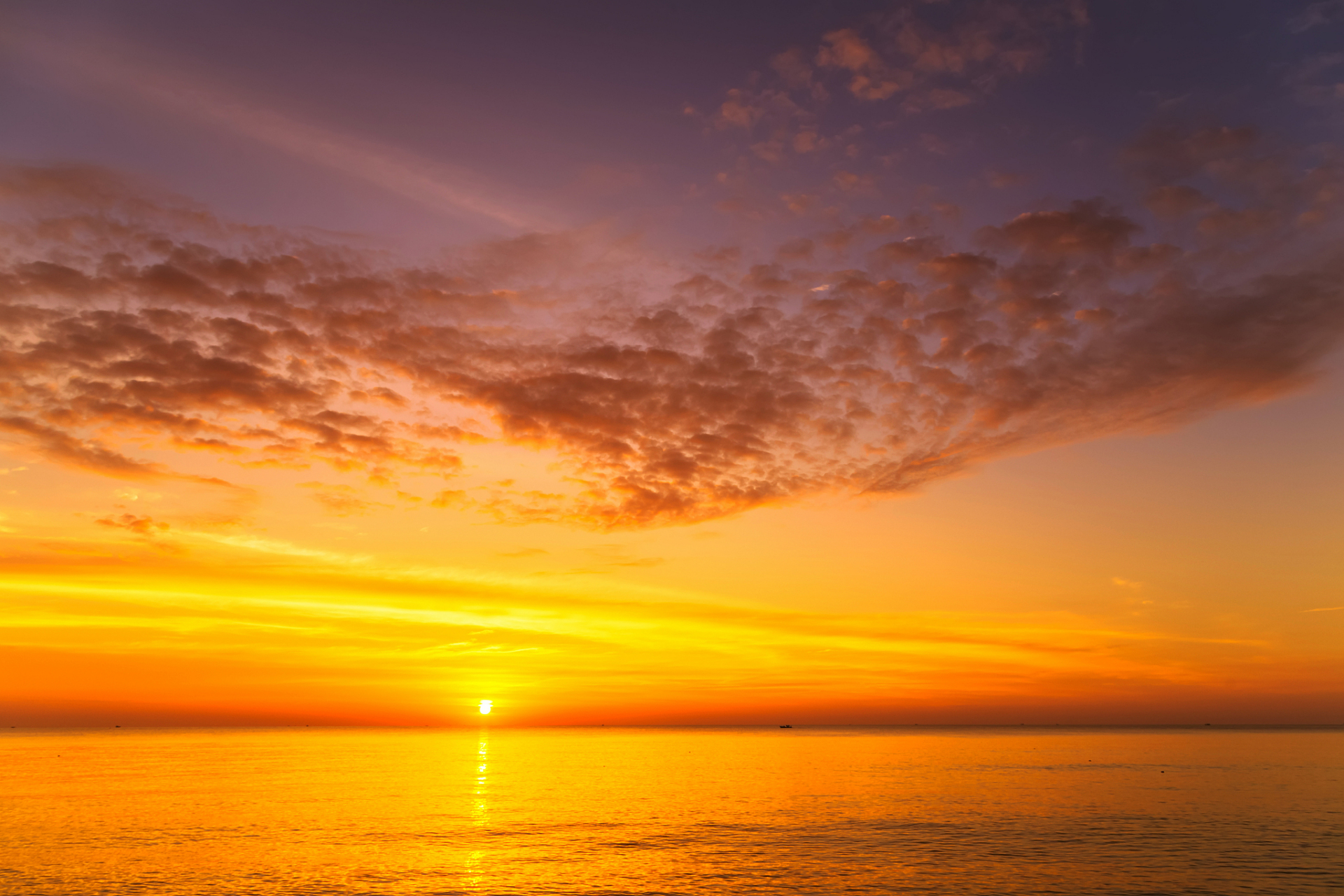 在黄昏时分,站在海边,观赏太阳缓缓落下,晚霞染红天际.