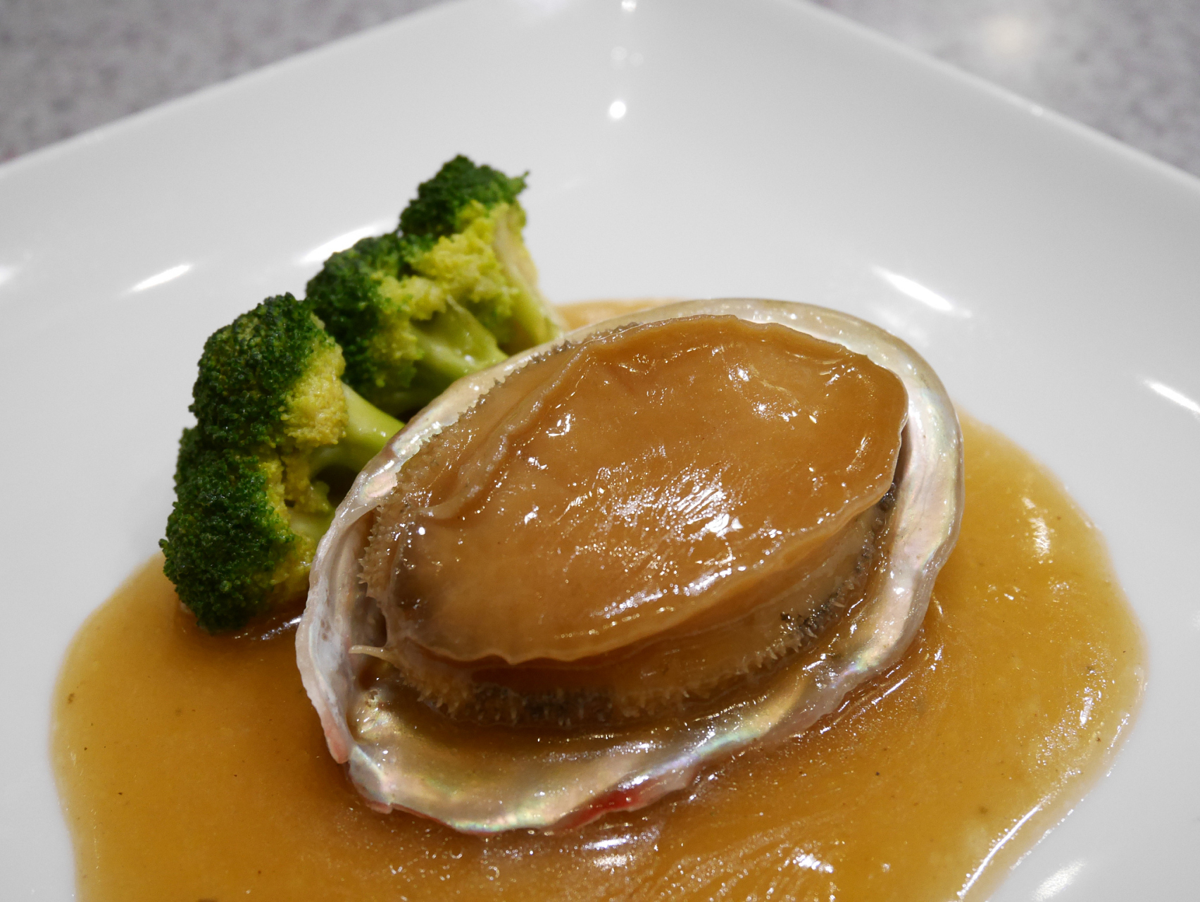 有一道独特的美食,它的名字与广州的历史紧密相连,它就是阿一鲍鱼