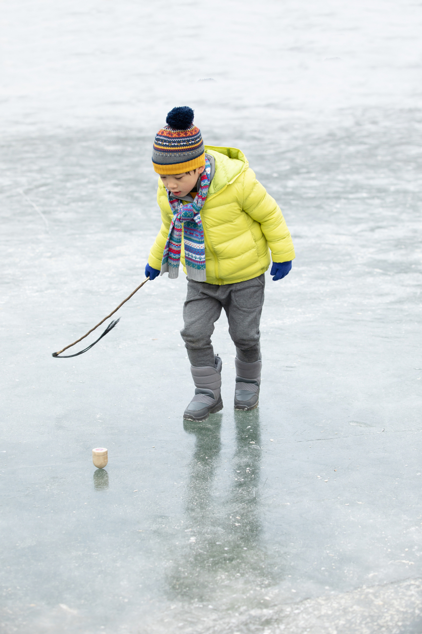来东北猫冬吧#   抽冰尜是很多东北小孩喜欢的冰上游戏,把一个木陀螺