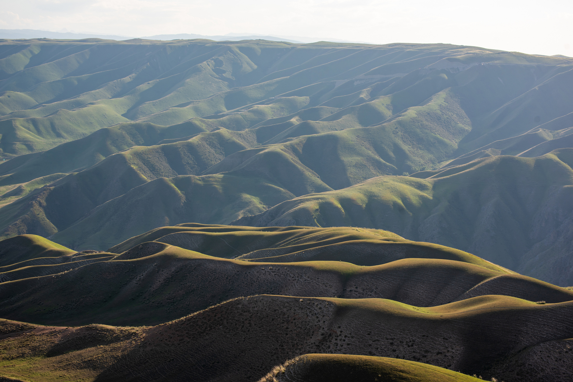 连绵起伏,意思是连续不断而且起伏不平.