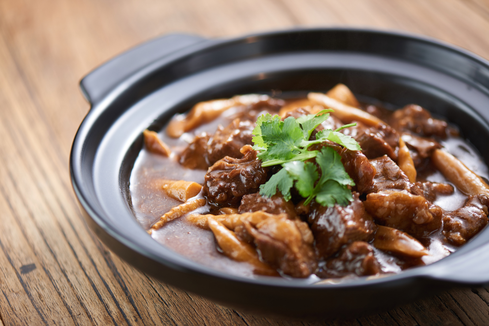 热锅凉油,加入少许豆瓣酱,姜片和八角等大料一起煸香,加入焯好的牛腩