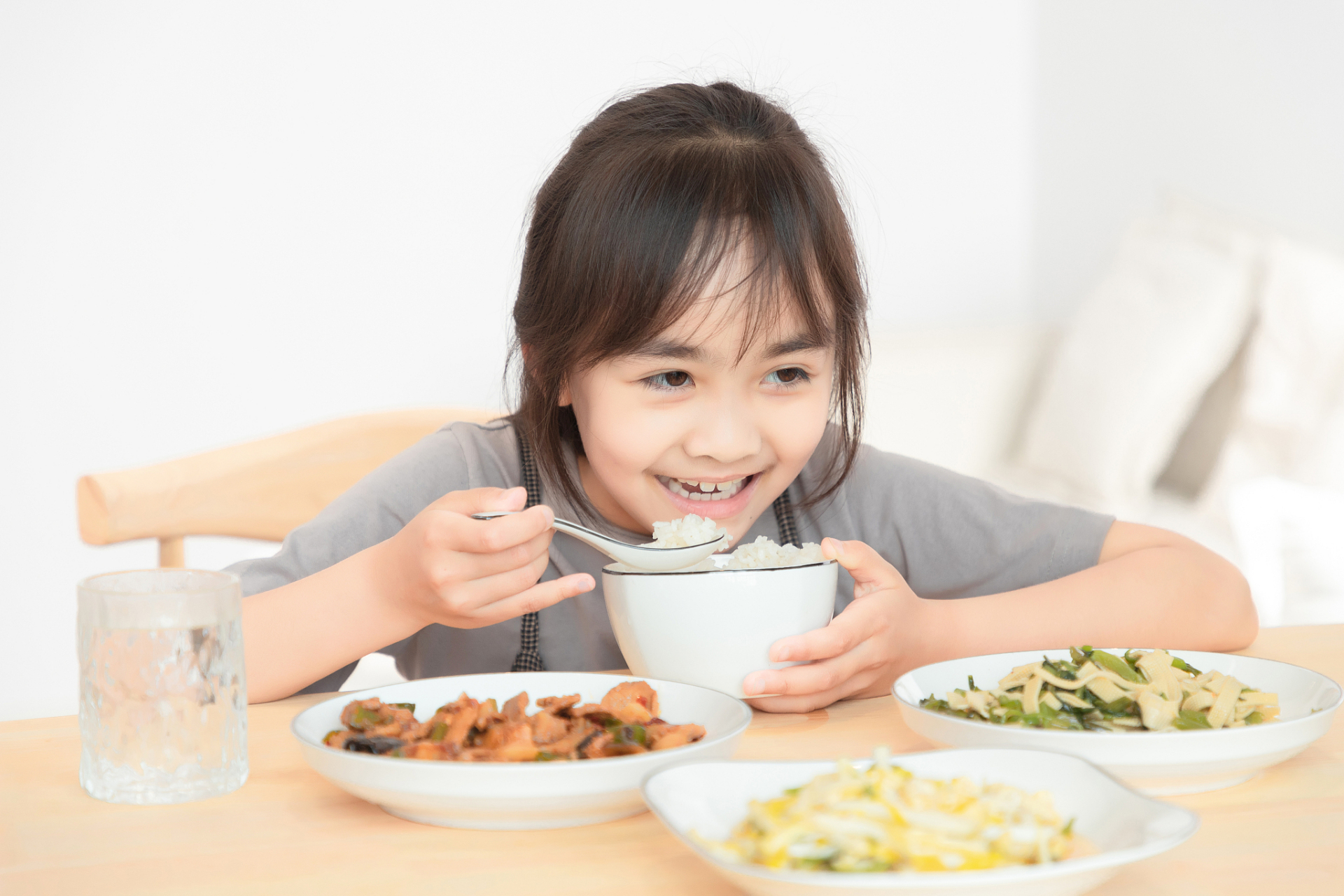 在清晨的第一缕阳光中,我的女儿正坐在餐桌前,享受着她的早餐.