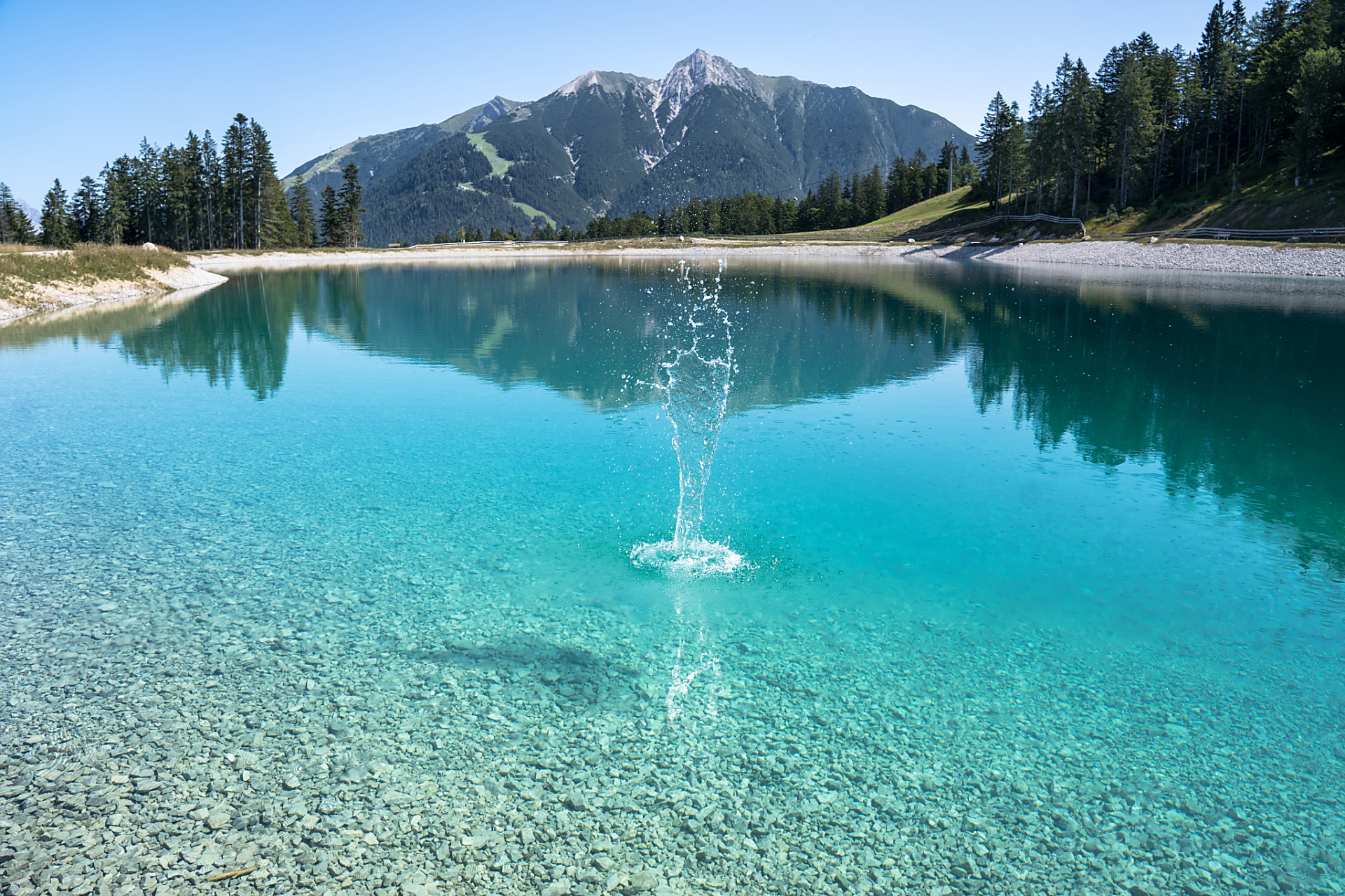 湖面上残冰缓缓融化,清澈见底的水面折射着阳光的光芒.