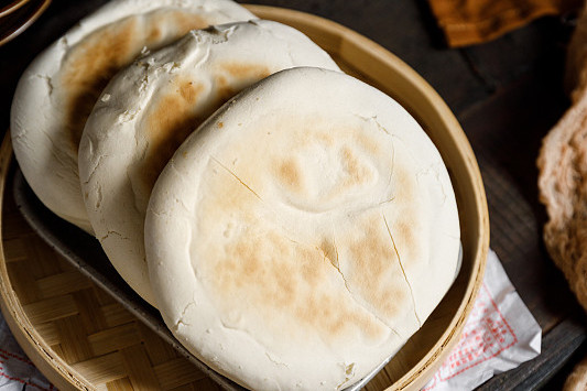 白吉馍是陕西西安的特色小吃,起源于唐朝,由白氏家族改良面点技艺制作