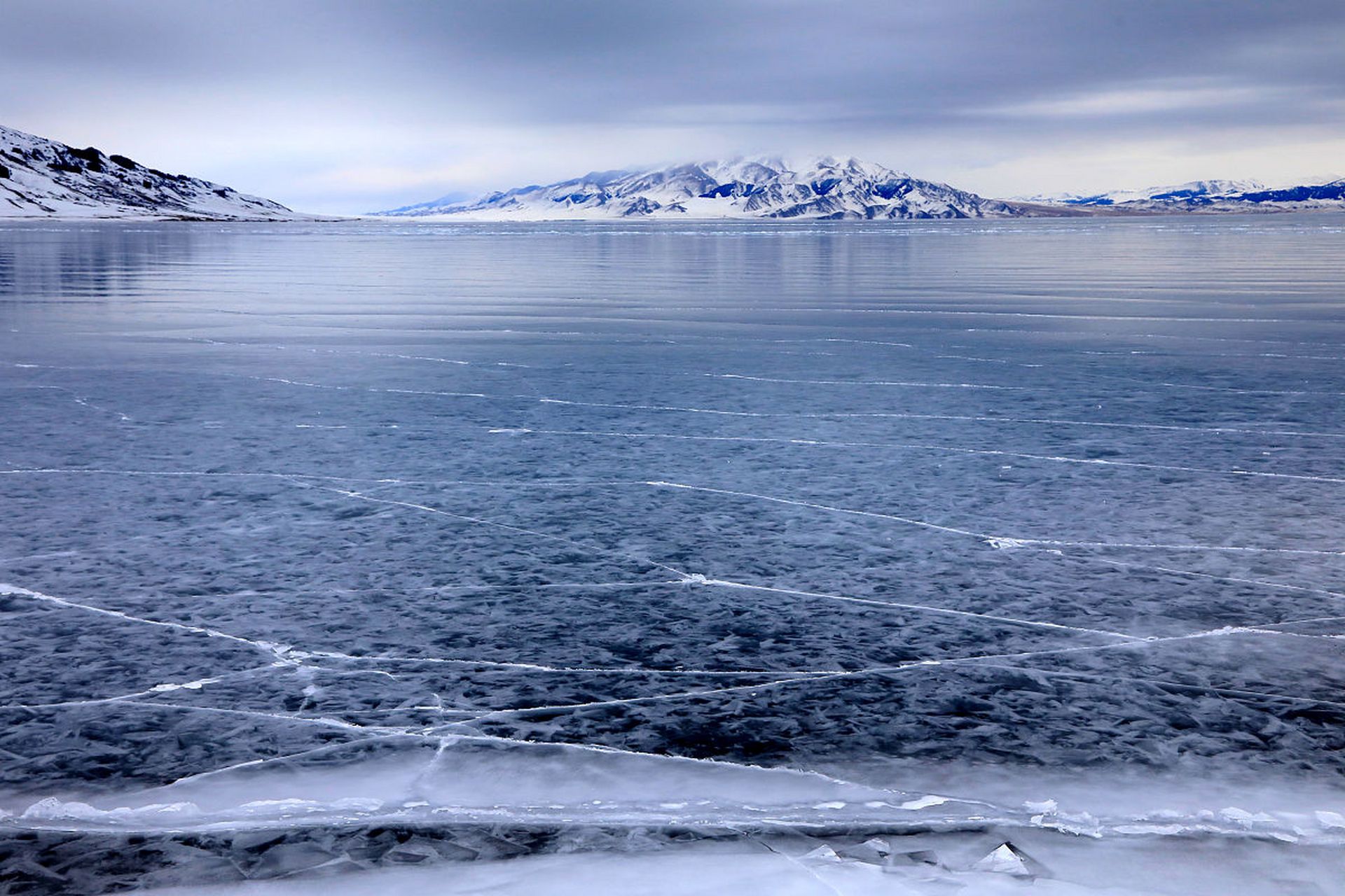 冬天的赛里木湖是一幅蓝白相间的美丽画卷,湖面闪烁着蓝色光芒的冰晶