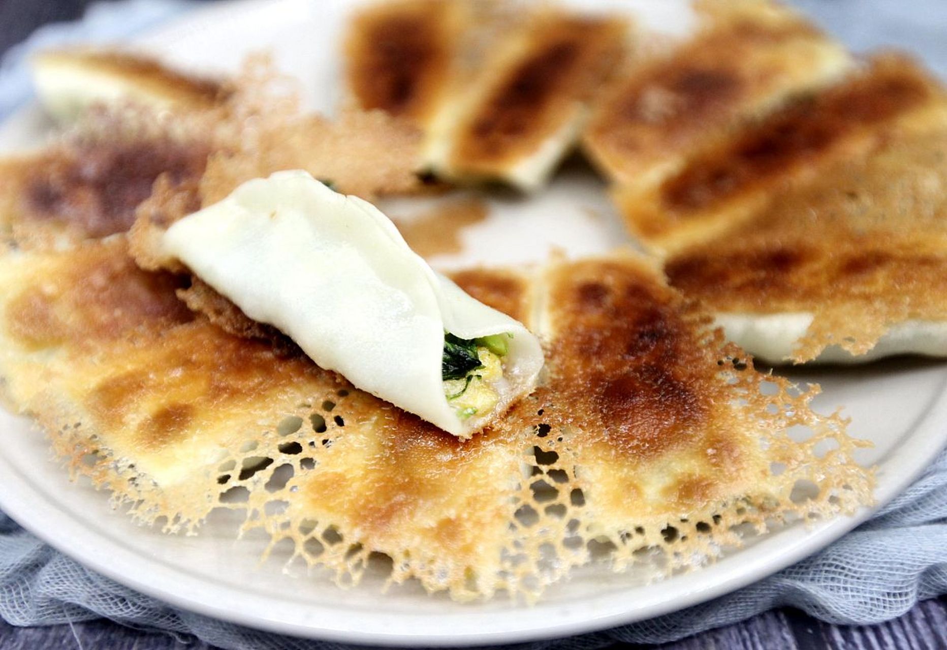 锅贴是一种中国传统的煎烙小吃,形状独特,其特点是锅底部烤得金黄酥脆