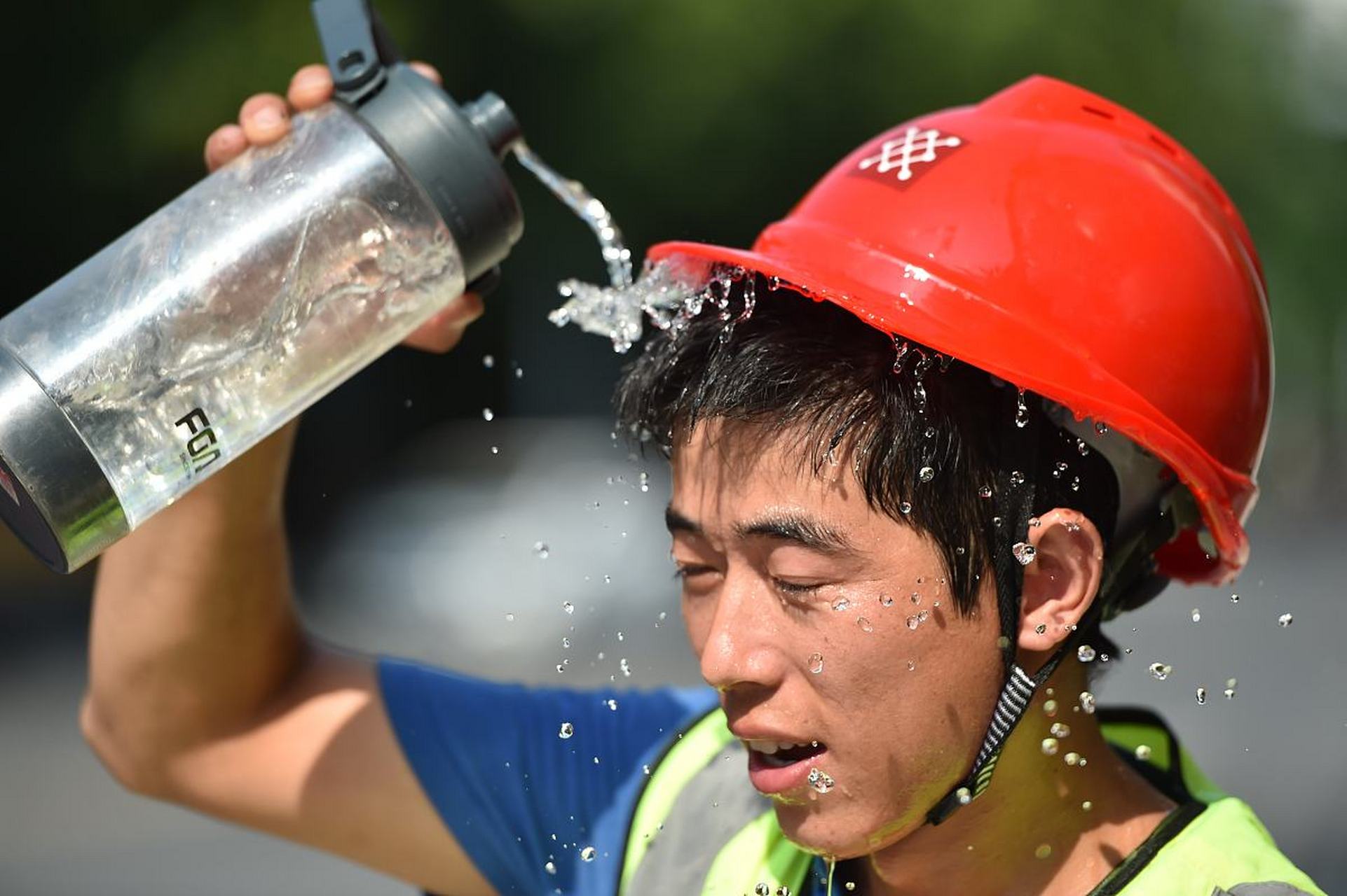 而是解决苦难:  一群农民工在大太阳底下辛苦干活,大汗淋漓,面对镜头