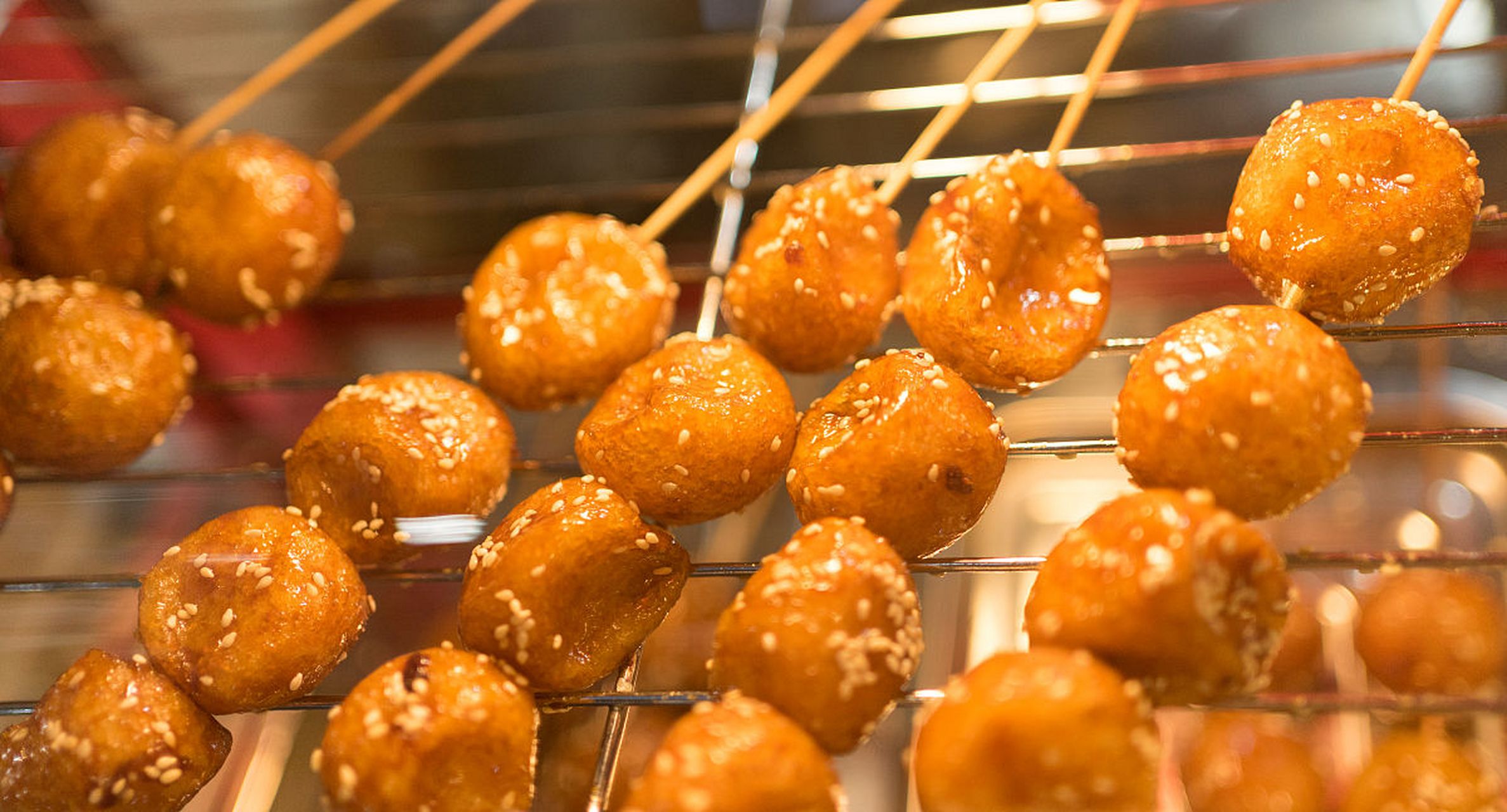 是用糯米炸成的圆形空心团子,炸好后淋上亮晶晶的糖稀,再用竹签串起