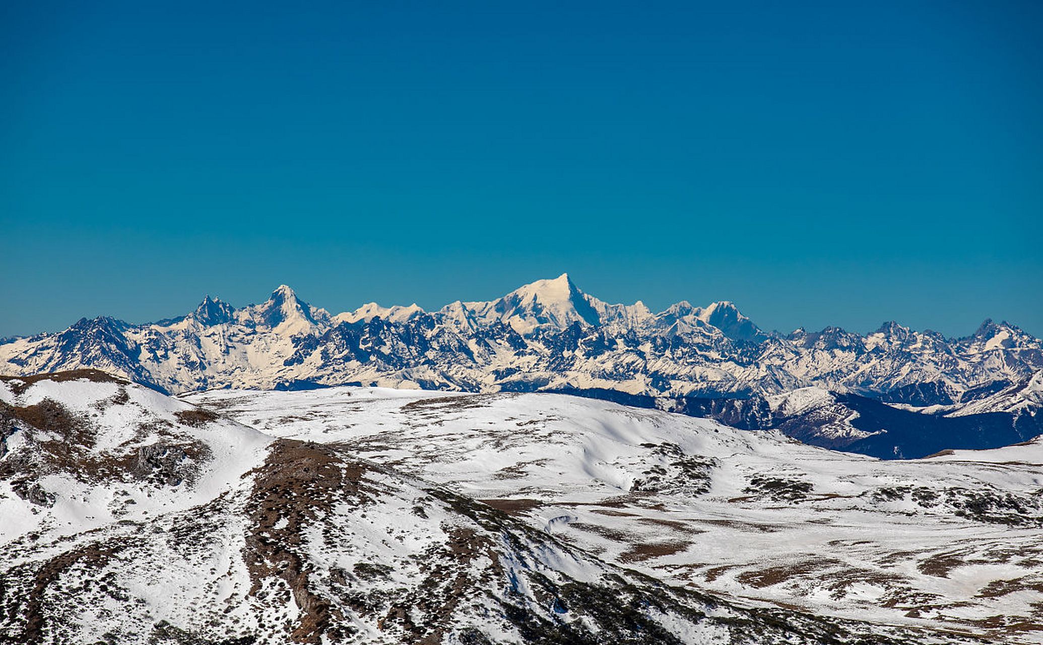 雪山之巅,白雪皑皑,银光闪闪.山间的云雾缭绕,犹如仙境般的美景.