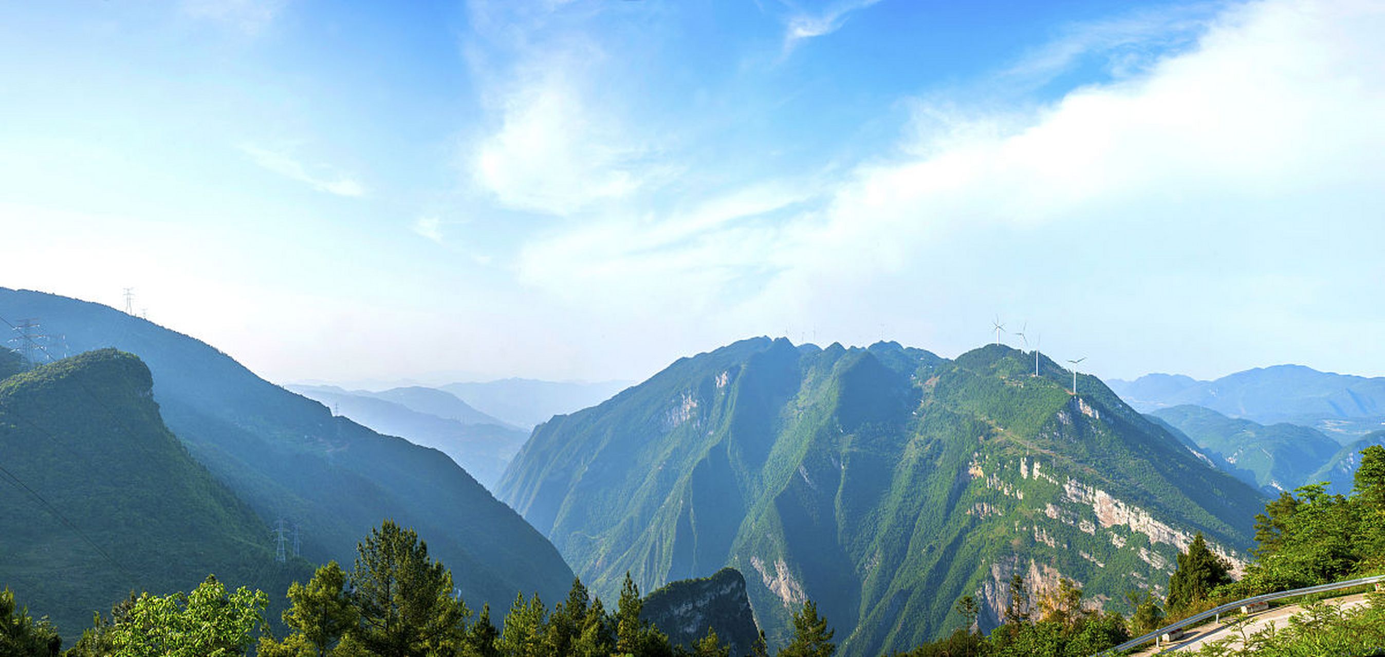 蓝天白云下,群山连绵起伏,云雾缭绕.