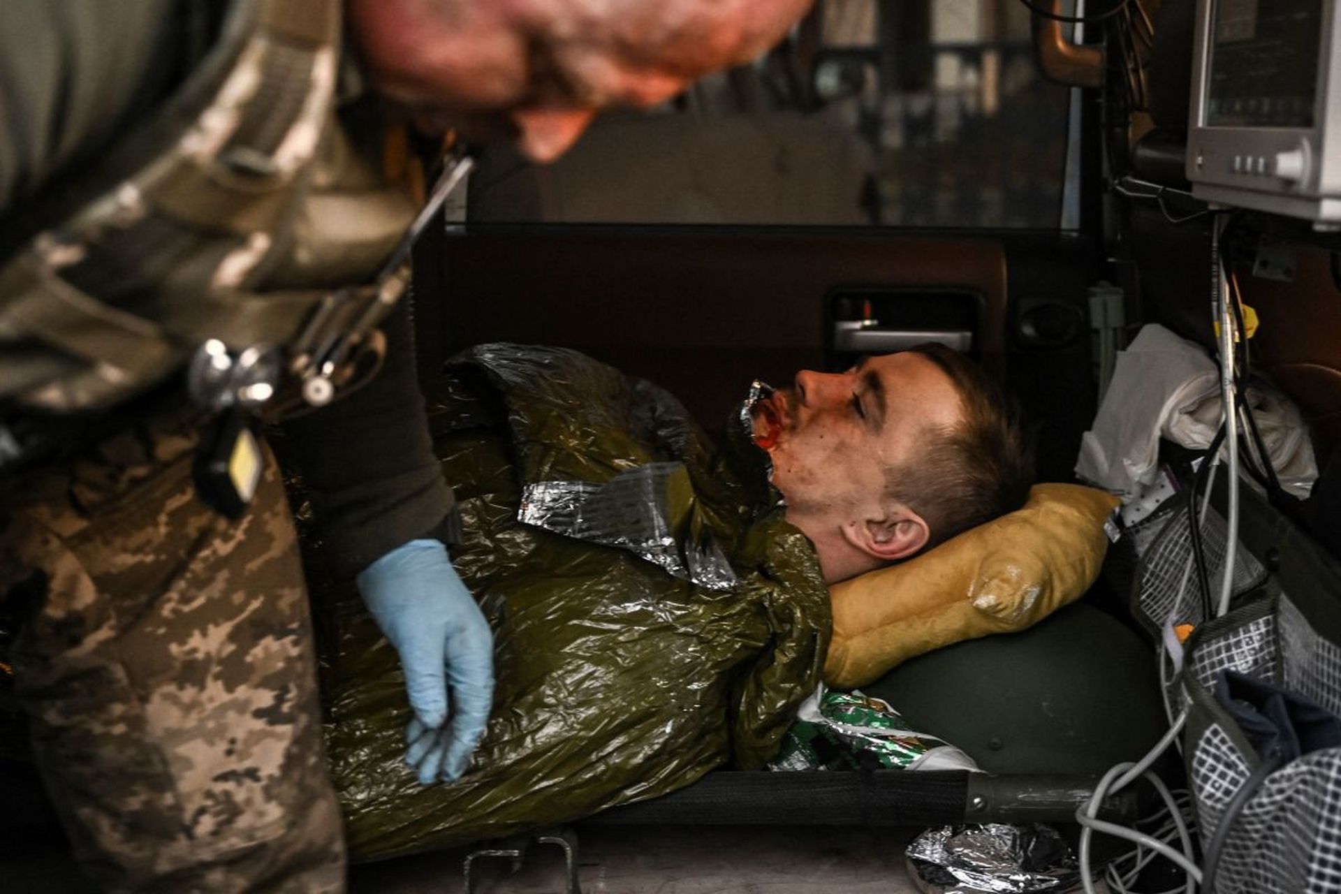 一名乌克兰士兵腿部中弹,流血后撤退.俄罗斯军队在门外,枪声很密集