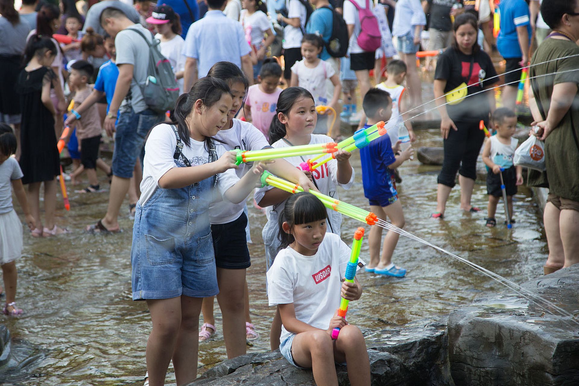 快乐地玩水枪游戏,与小伙伴们打得不亦乐乎.