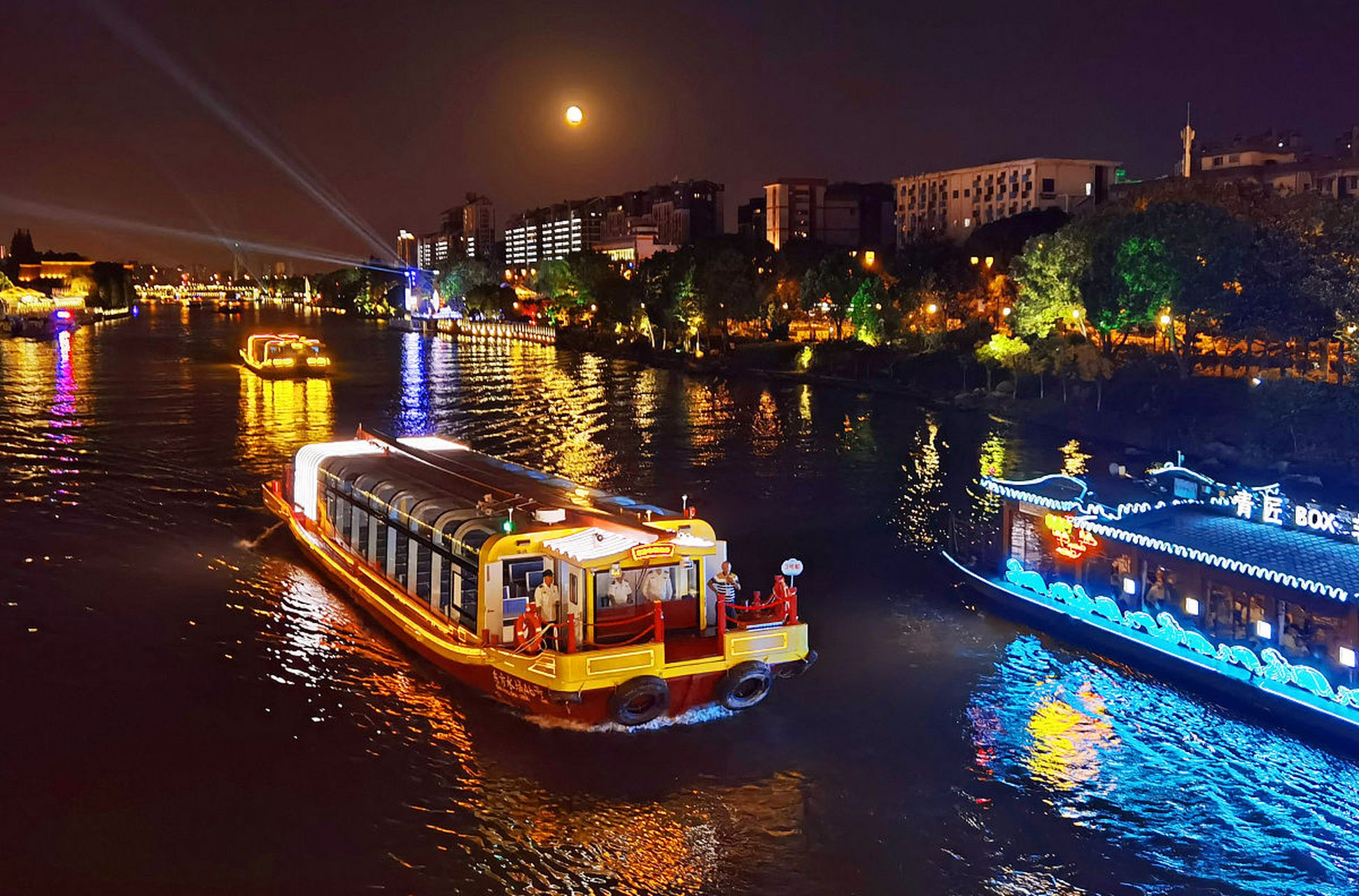 苏州夜晚的船游古运河如诗如画,两岸灯光倒映水中五彩斑斓,古建筑庄重