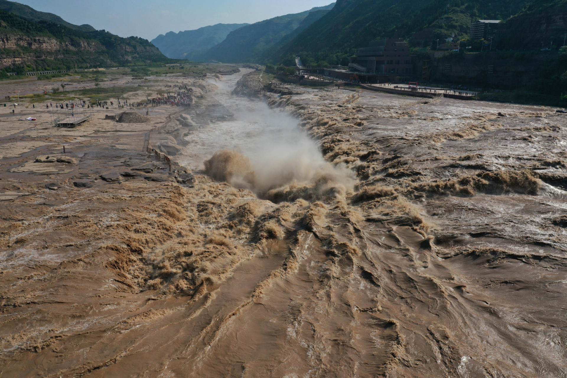 水流奔腾而下,形成壮观的景象,水雾缭绕,气势磅礴.