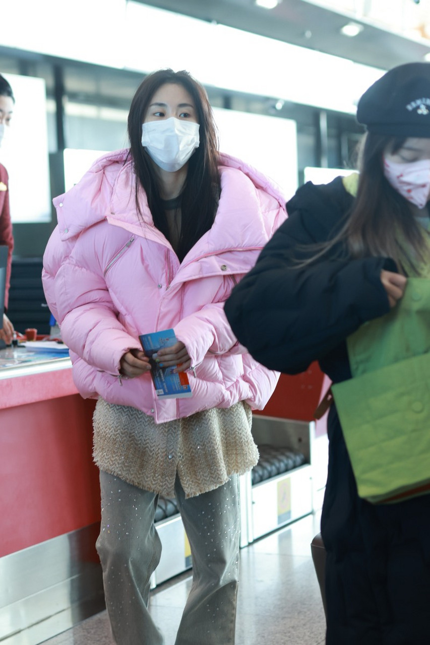 张碧晨穿粉色羽绒外套现身首都机场.